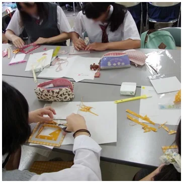 都内高等学校にて家庭科クラブ交流セミナーでカルトナージュ制作を実施した際の生徒達が素材を切って制作を進めている様子の写真