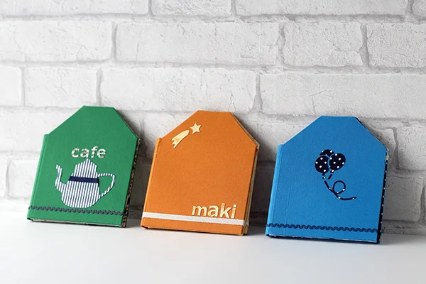 家庭科教材：カルトナージュの教材キット写真：ハウス型ダブルフォトフレームの完成した作品／３作品を折りたたんだ状態